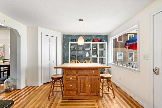 50 Walnut St, Northampton, MA 01060 - dining space featuring light wood-type flooring, plenty of natural light, baseboards, and arched walkways