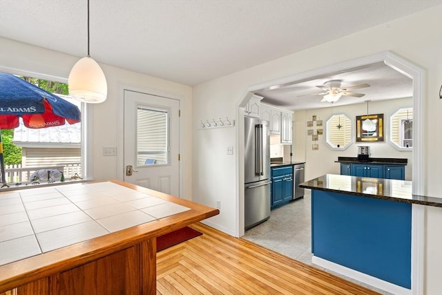 50 Walnut St, Northampton, MA 01060 - kitchen with appliances with stainless steel finishes, blue cabinets, a ceiling fan, hanging light fixtures, and white cabinetry