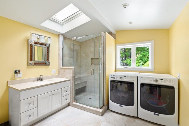 50 Walnut St, Northampton, MA 01060 - bathroom featuring a skylight, washing machine and dryer, vanity, a stall shower, and tile patterned floors