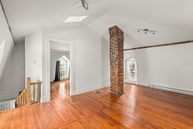 50 Walnut St, Northampton, MA 01060 - additional living space featuring decorative columns, a skylight, vaulted ceiling, wood-type flooring, and a baseboard heating unit