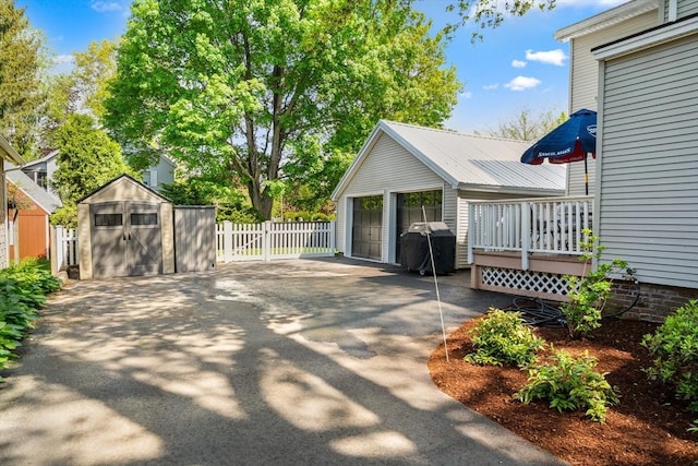 50 Walnut St, Northampton, MA 01060 - view of patio featuring an outbuilding, a storage shed, fence, a garage, and a grill