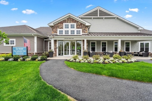 12109 Peters Farm Way Unit 109, Westborough, MA 01581 - back of property featuring stone siding, outdoor lounge area, a lawn, a standing seam roof, and metal roof