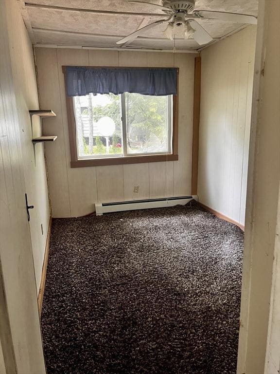 40 Papoose Lake Dr, Heath, MA 01346 - spare room featuring a baseboard radiator, ceiling fan, wooden walls, and baseboards
