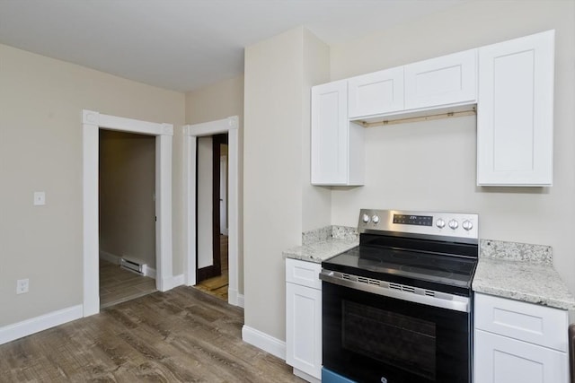 kitchen with stainless steel range with electric stovetop, white cabinetry, a baseboard heating unit, dark wood-type flooring, and light stone counters