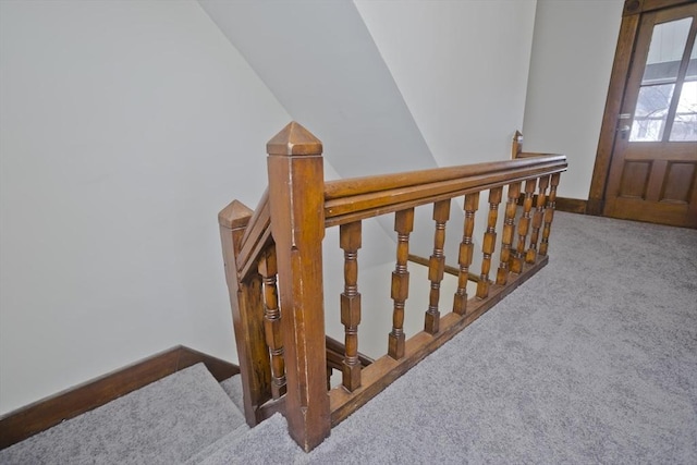 stairway featuring carpet flooring and lofted ceiling