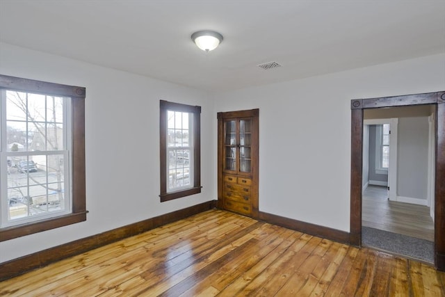 empty room featuring plenty of natural light and hardwood / wood-style floors