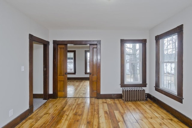 spare room with radiator and light wood-type flooring