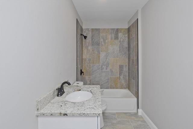 full bathroom featuring toilet, vanity, and tiled shower / bath