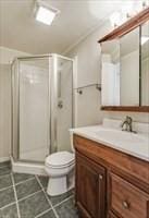 306 Columbus Ave Unit 2, Boston, MA 02116 - bathroom with vanity, a shower stall, toilet, and tile patterned floors