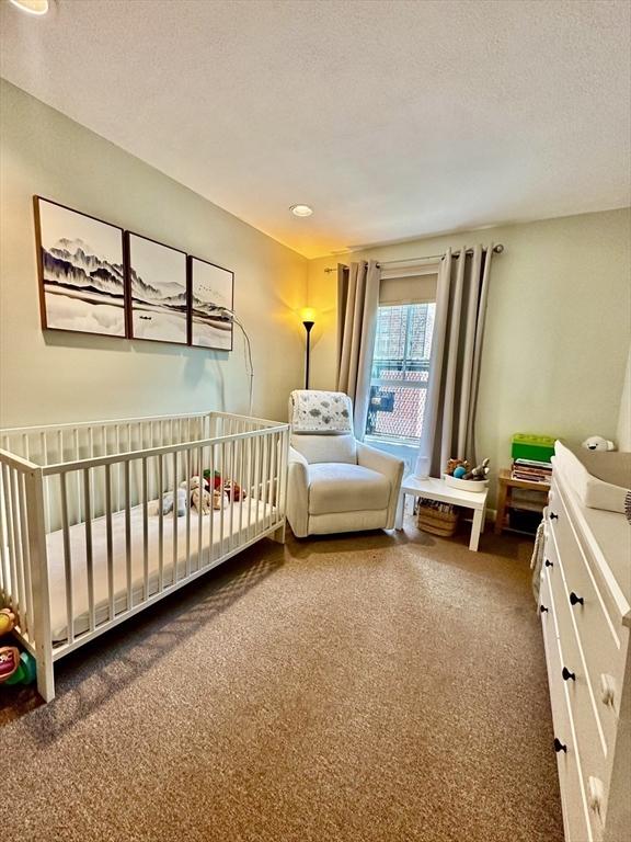 306 Columbus Ave Unit 2, Boston, MA 02116 - carpeted bedroom with a textured ceiling and a crib