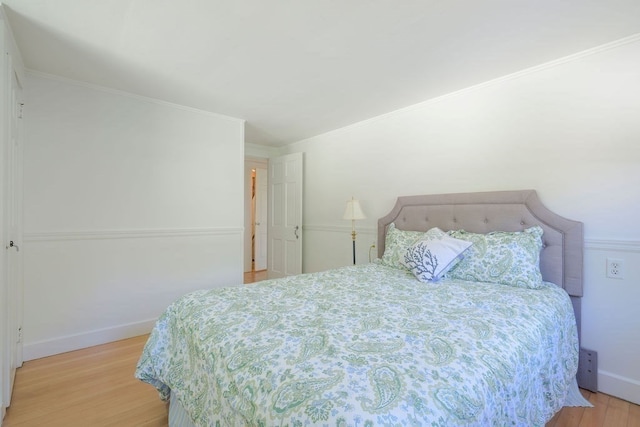 bedroom with crown molding and light wood-type flooring