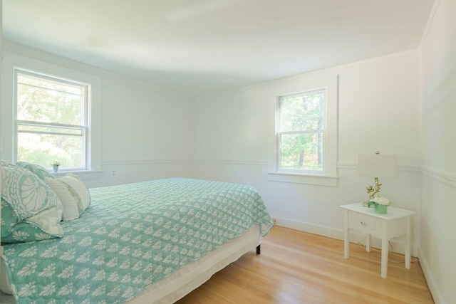 bedroom with ornamental molding and hardwood / wood-style floors