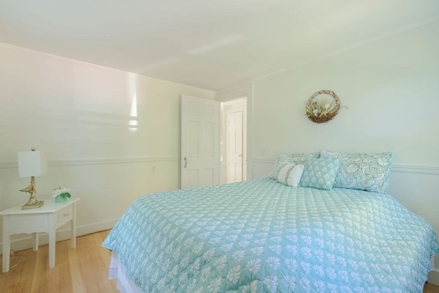 bedroom featuring ornamental molding and light hardwood / wood-style floors