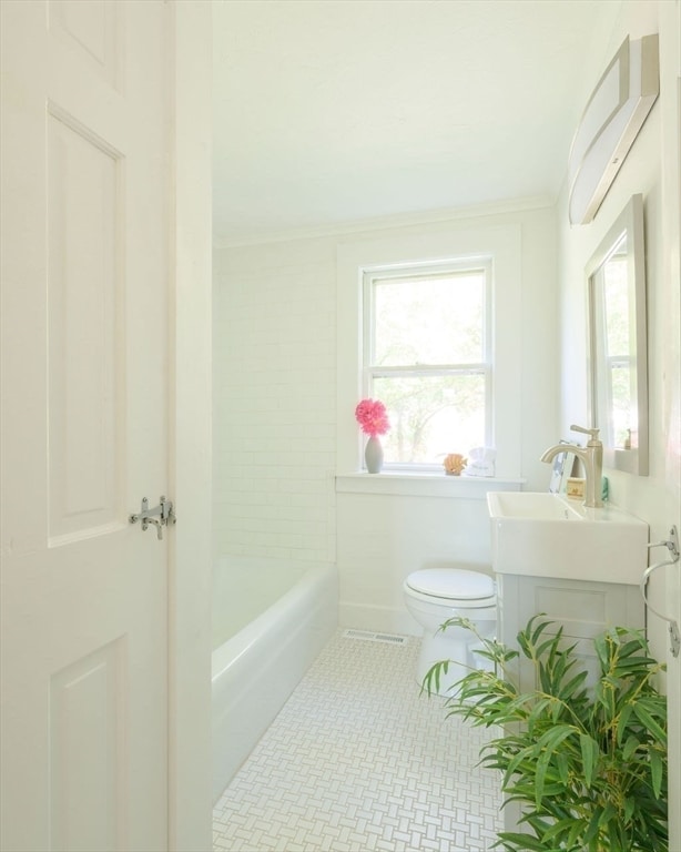 full bathroom featuring vanity, crown molding, shower / washtub combination, and toilet