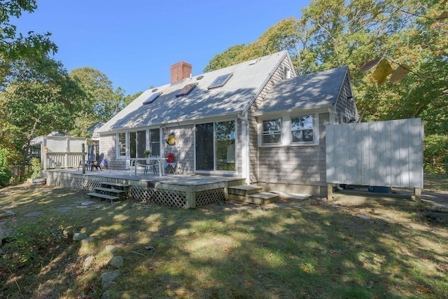 back of house with a wooden deck and a lawn