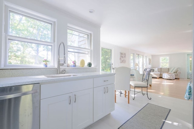 kitchen with dishwasher, light hardwood / wood-style flooring, sink, light stone countertops, and white cabinetry