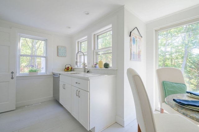 kitchen featuring crown molding, white cabinets, dishwasher, and sink