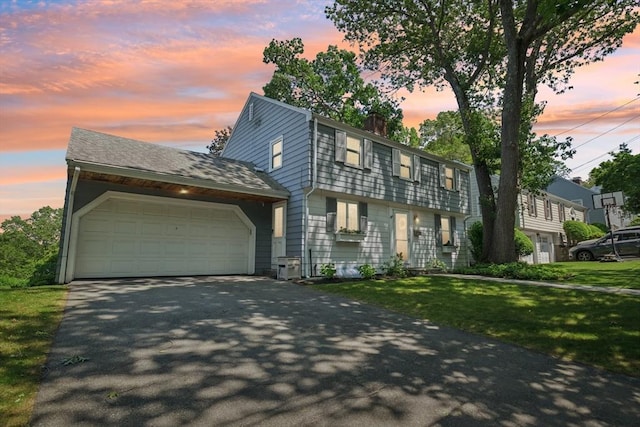 56 Conrad Rd, Melrose, MA 02176 - colonial home with asphalt driveway, an attached garage, a chimney, and a front yard