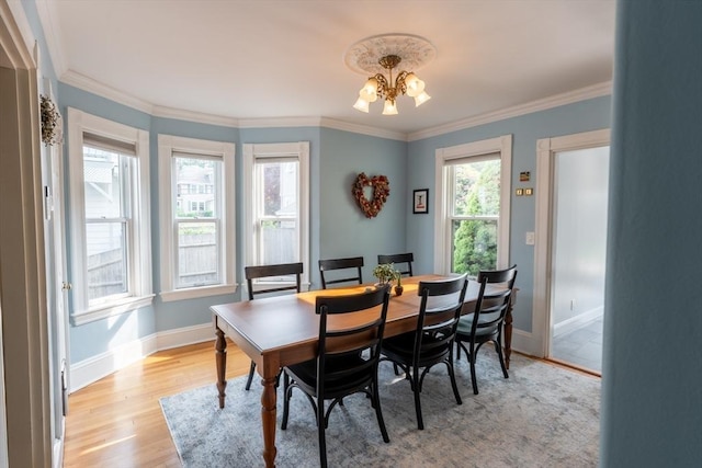 37 Chestnut St, Stoneham, MA 02180 - dining space featuring a chandelier, baseboards, light wood-style floors, and crown molding