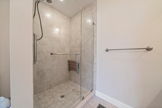 full bathroom featuring baseboards and a shower stall