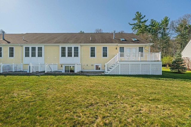 back of property with stairs, a wooden deck, and a yard
