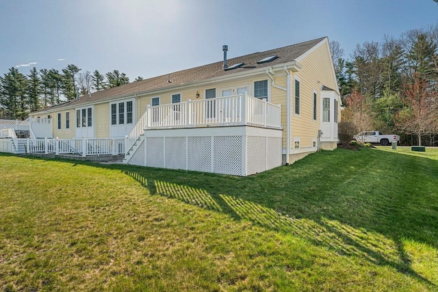 rear view of property featuring a lawn, a wooden deck, and stairway