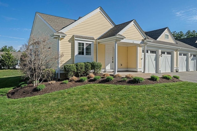 view of front facade with driveway, a front lawn, roof with shingles, and a garage