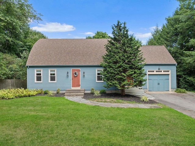 view of front facade with a garage, driveway, a shingled roof, fence, and a front yard