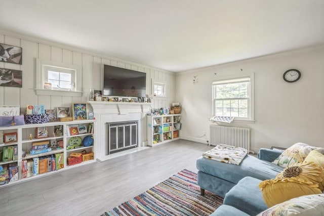 521 Pleasant St, Weymouth, MA 02190 - living area with radiator, plenty of natural light, wood finished floors, a fireplace with flush hearth, and crown molding