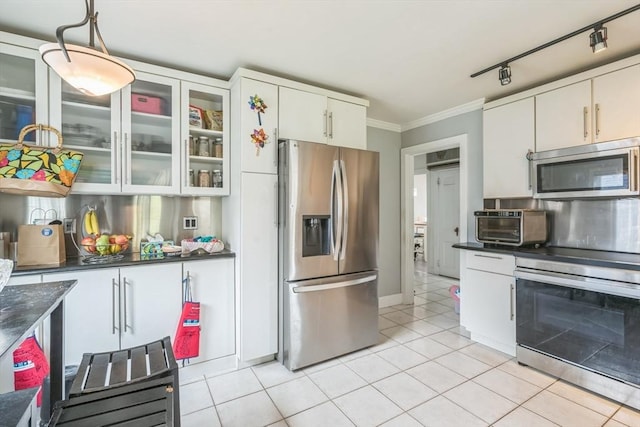 521 Pleasant St, Weymouth, MA 02190 - kitchen featuring appliances with stainless steel finishes, ornamental molding, light tile patterned floors, dark countertops, and white cabinets