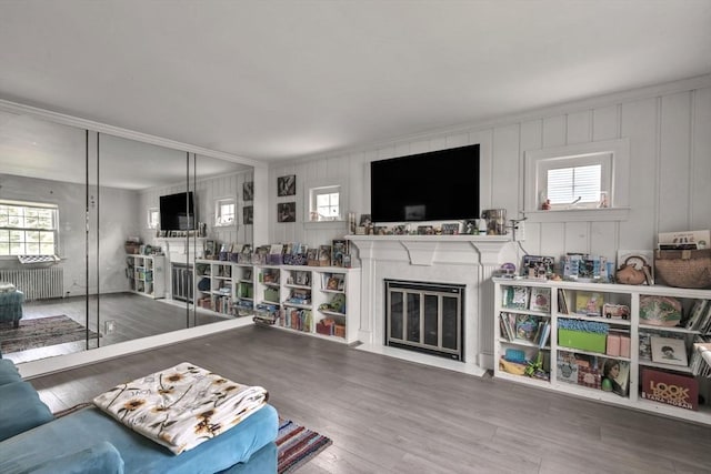 521 Pleasant St, Weymouth, MA 02190 - living area featuring radiator, healthy amount of natural light, wood finished floors, a premium fireplace, and ornamental molding