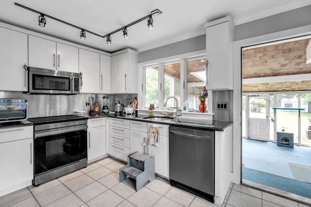 521 Pleasant St, Weymouth, MA 02190 - kitchen featuring stainless steel appliances, dark countertops, and decorative backsplash