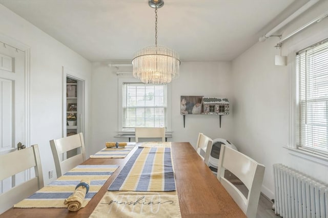 521 Pleasant St, Weymouth, MA 02190 - dining space with radiator, a chandelier, and plenty of natural light