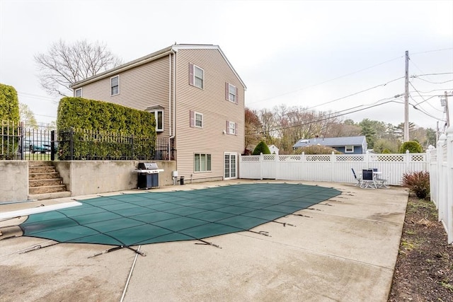 view of swimming pool with fence, grilling area, a patio area, and a fenced in pool