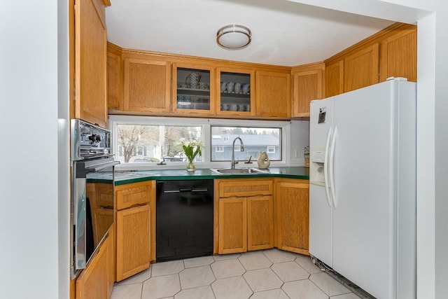 kitchen featuring black appliances, dark countertops, brown cabinets, and a sink