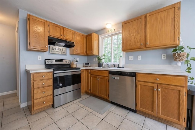 25 Sharlene Ln Unit 25, Plainville, MA 02762 - kitchen featuring stainless steel appliances, under cabinet range hood, light countertops, light tile patterned floors, and brown cabinetry