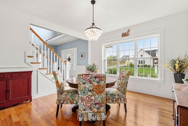15 Day Lily Ln, Walpole, MA 02081 - dining area featuring a decorative wall, a chandelier, light wood finished floors, stairs, and wainscoting