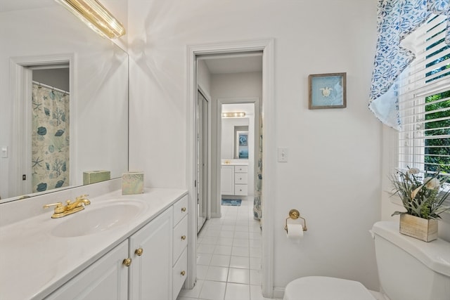 bathroom with vanity, toilet, and tile floors