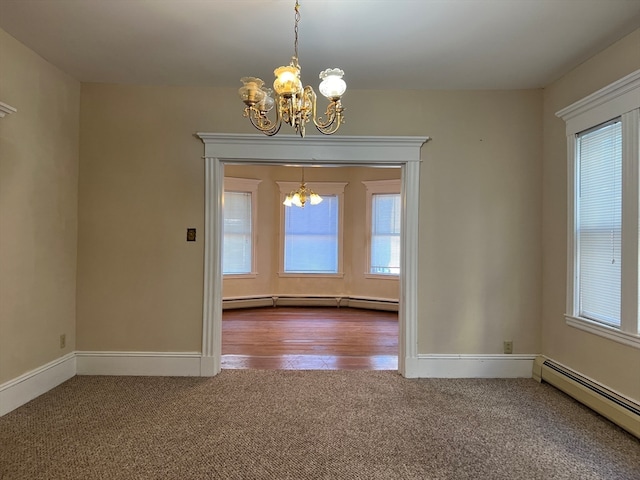 spare room featuring hardwood / wood-style flooring, a baseboard radiator, and a chandelier