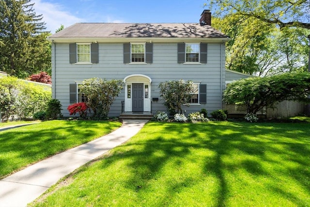 colonial house with a chimney and a front lawn