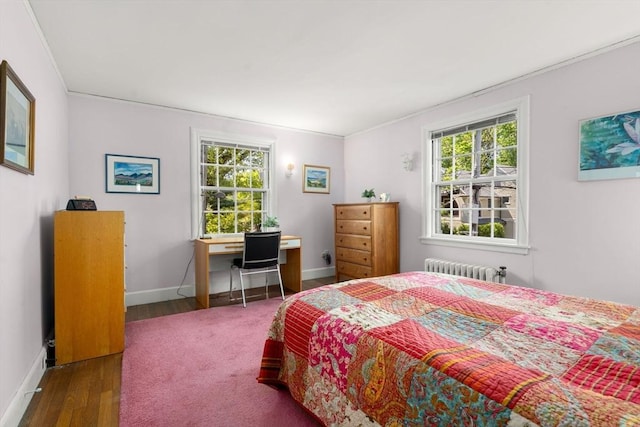 bedroom featuring radiator, baseboards, ornamental molding, and wood finished floors