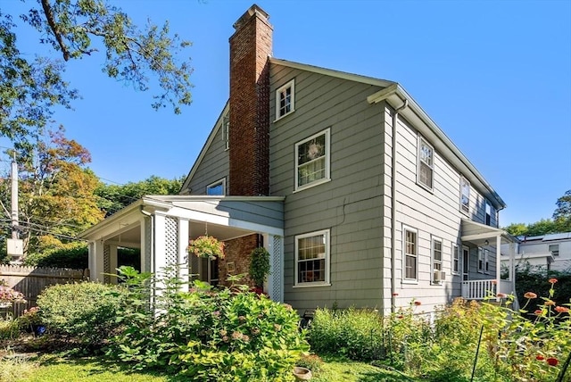 back of property featuring a chimney and fence