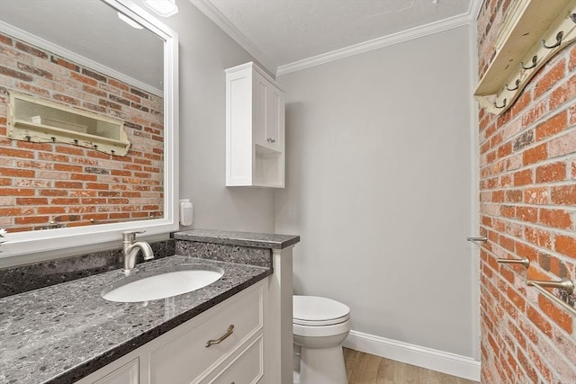31 Spectacle Hill Rd, Bolton, MA 01740 - bathroom featuring crown molding, wood finished floors, toilet, vanity, and brick wall
