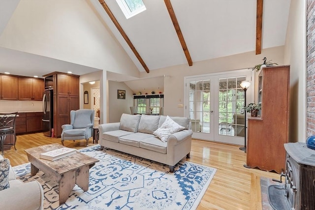 31 Spectacle Hill Rd, Bolton, MA 01740 - living room featuring light wood-type flooring, a skylight, high vaulted ceiling, beam ceiling, and a wood stove