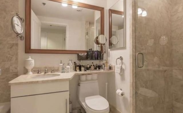 full bathroom featuring vanity, toilet, and a stall shower