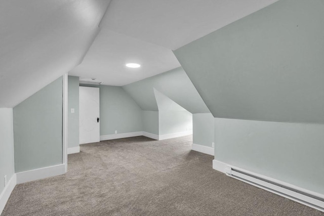 bonus room featuring a baseboard heating unit, lofted ceiling, and light colored carpet