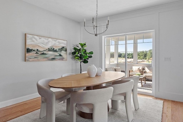 dining area featuring light hardwood / wood-style floors and a notable chandelier