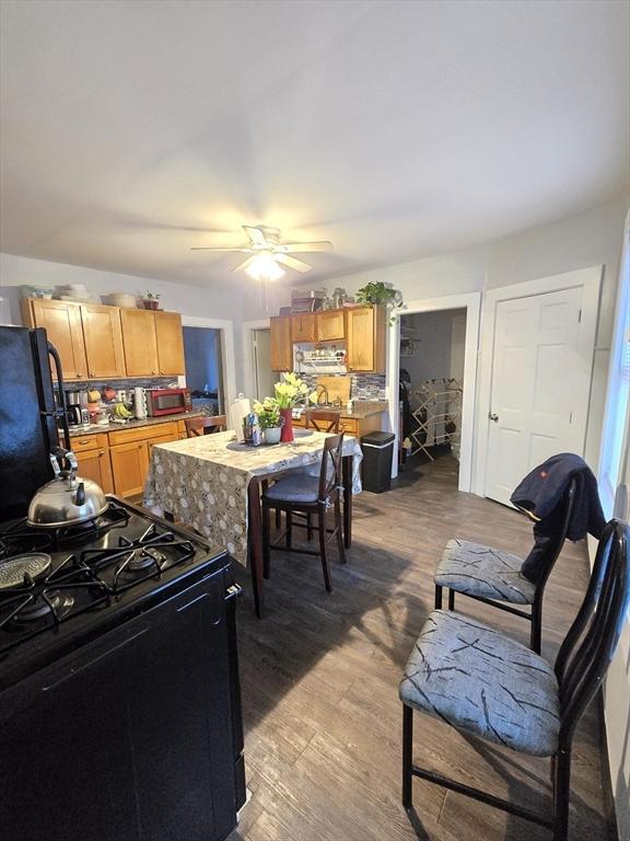 kitchen with wood-type flooring, ceiling fan, and black appliances