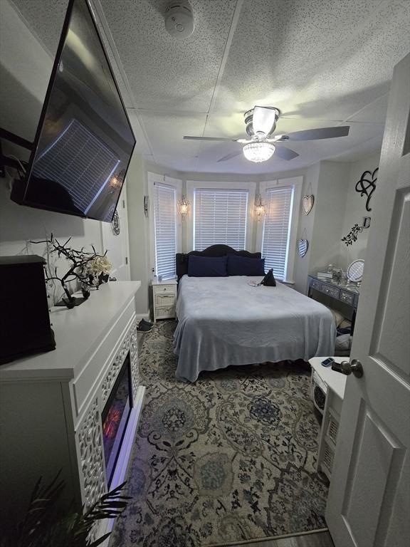 bedroom featuring ceiling fan and a textured ceiling