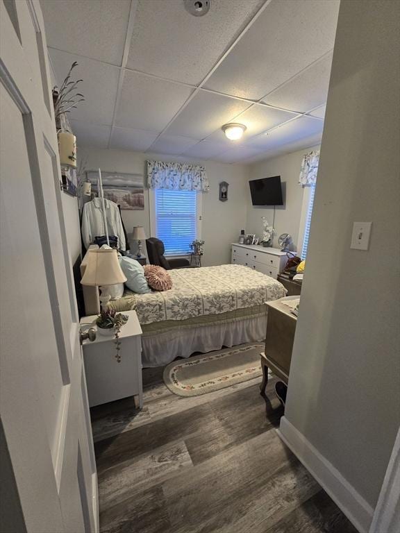 bedroom with dark hardwood / wood-style floors and a drop ceiling